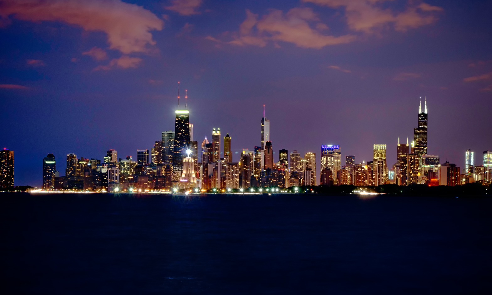 Chicago skyline lit up across the lake at night